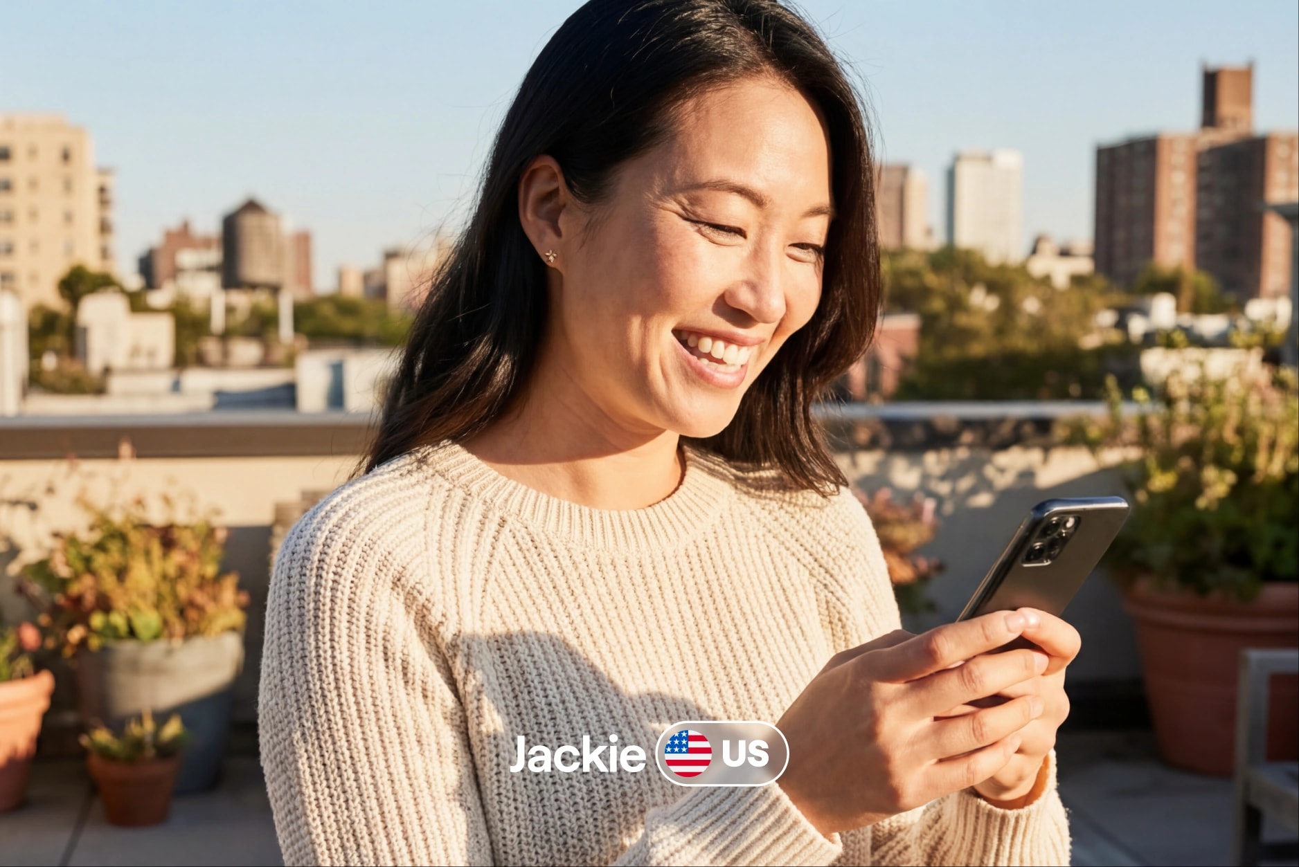 Jackie from the US smiling at her phone on a rooftop