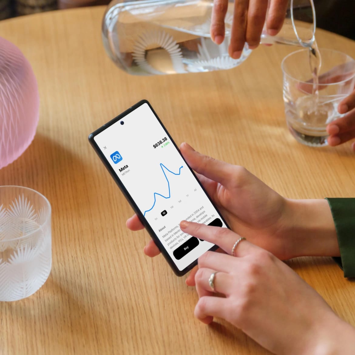 Viewing Meta stock chart on Morse invest at a dinner table