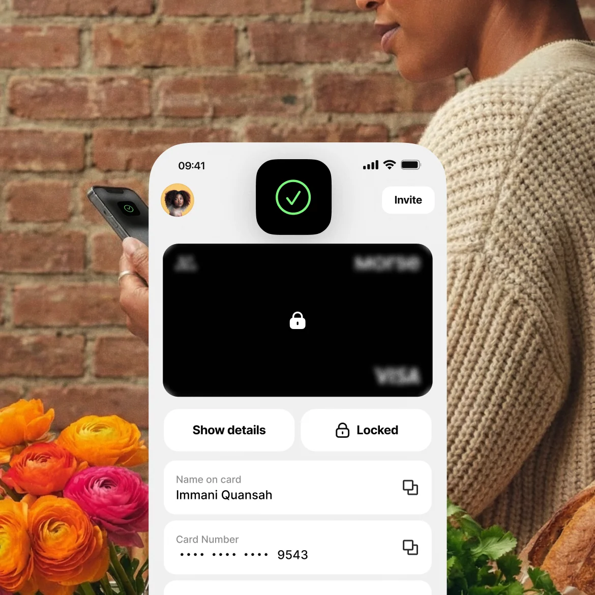 A locked Morse debit card on the app, held by a person standing by a flower stall